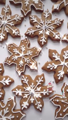 some very pretty decorated cookies on a white table with snowflakes and icing