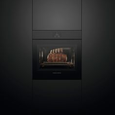 an oven with food cooking in it and on the side, black walls are visible