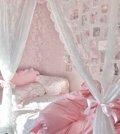 a bedroom with pink and white decor on the walls, curtains and bedding in it