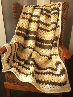 a crocheted blanket sitting on top of a wooden chair