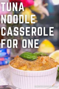 tuna noodle casserole for one in a white dish with basil on top