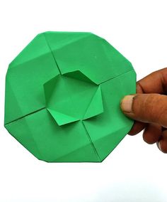 someone is holding an origami piece in their hand and pointing it at the top