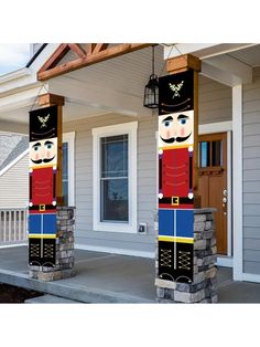 two large wooden nutcrackers sitting on top of a porch next to a house