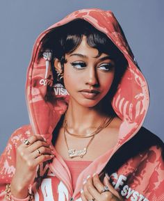 a woman wearing a pink hoodie and jewelry