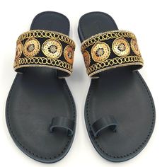 "--------ALL ORDERS CAN BE SHIPPED VIA DHL EXPRESS WORLDWIDE--------- 100% Leather 100% Handmade *Boho ethnic sandals, are one of our top summer choices. Made of authentic Vachetta leather, with a toe ring and a foot strap in a black-gold boho pattern. They feature special cushioned insoles. *Details  -Vachetta leather straps  -Vachetta leather foam padded insoles -Lightweight rubber soles of excellent quality  -Heel 8mm (0.31\")  -Round toe -Handcrafted in Greece  *Extra tips  Fit tip - true to size, width: medium. Go up to the nearest whole size if you take a half size or if you have wide feet. Avoid light, always clean with a dry cotton cloth.  *Click here to see the entire collection https://www.etsy.com/shop/ChristieChiaraSandal?ref=seller-platform-mcnav *WOMEN - SIZE CHART  EUUSUKSol Adjustable Toe Ring Slip-on Sandals For Vacation, Adjustable Slip-on Toe Ring Sandals For Vacation, Black Bohemian Flip Flops For Vacation, Bohemian Black Flip Flops For Beach, Gold Slip-on Sandals For Beach, Gold Flat T-strap Sandals For Beach, Traditional Adjustable Toe Ring Sandals For Beach, Traditional Leather Flip Flops For Festivals, Gold T-strap Sandals With Round Toe For Beach