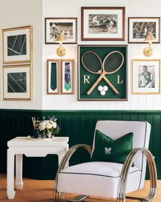 a tennis racket is hanging on the wall above a white chair with green pillows