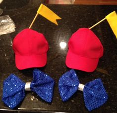 two red and blue bow ties on top of a black table next to a baseball cap