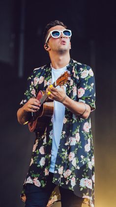 a man with sunglasses and a guitar on stage