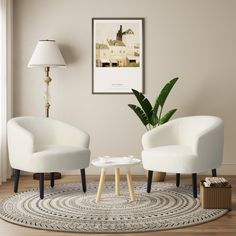 two white chairs sitting on top of a rug in a living room next to a lamp