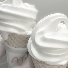 two white cups with whipped cream on them