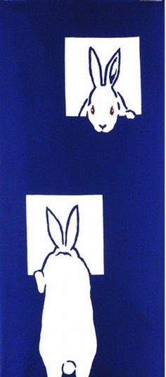 a blue towel with white rabbit faces on the front and back of it's face