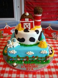 a birthday cake with a farm scene on the top and red barn in the background