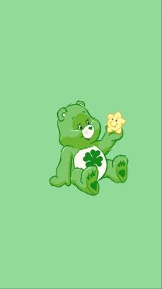 a green teddy bear holding a piece of food