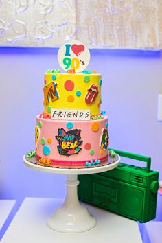 a brightly colored birthday cake sitting on top of a table