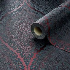 a roll of black and red wallpaper with an intricate design on it's surface