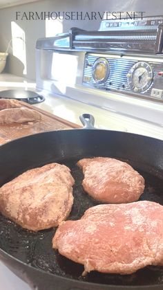 three meat patties cooking in a frying pan on the stove top next to an oven