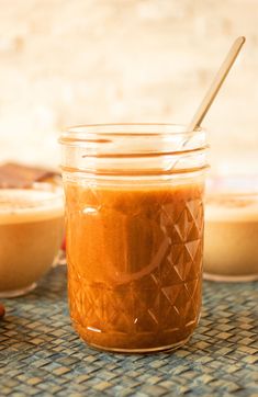 a glass jar filled with peanut butter next to other jars