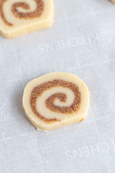 two cookies with cinnamon swirl on them sitting on a table next to some other cookies