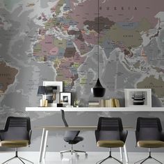 three chairs are sitting in front of a desk with a world map on the wall