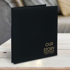 a black book sitting on top of a wooden table