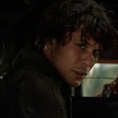 a young man sitting in the back seat of a car