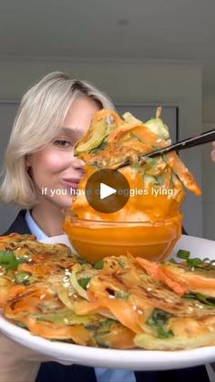 a woman holding a plate with food on it