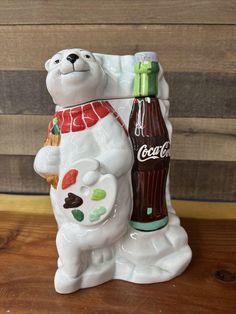 a ceramic polar bear holding a coca cola bottle