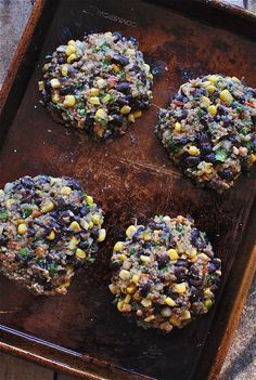 three hamburgers with black beans and corn on a baking sheet