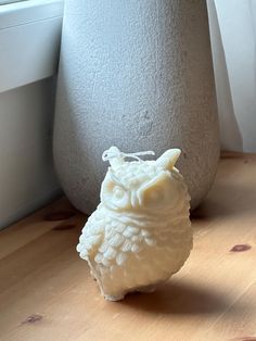 an owl figurine sitting next to a window sill