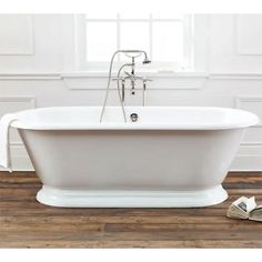 a white bath tub sitting on top of a wooden floor