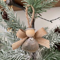 an ornament hanging from a christmas tree with pine cones and twine wrapped around it