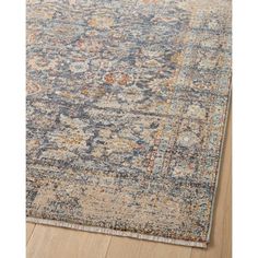 an area rug with blue, orange and yellow colors on top of wood flooring