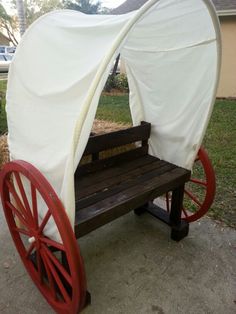 a wooden bench sitting next to a covered wagon