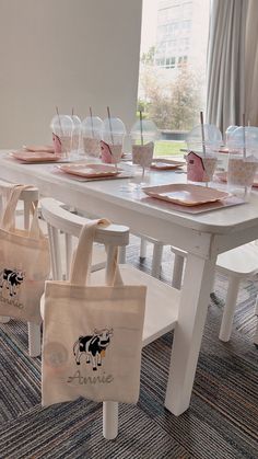 the table is set up with plastic cups and totes on it, along with pink napkins