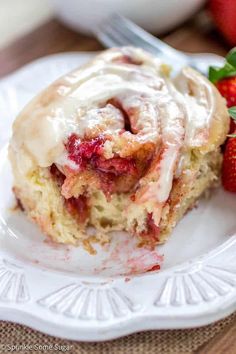 a piece of strawberry roll on a plate with strawberries