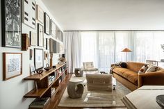 a living room filled with lots of furniture and pictures on the wall next to a window