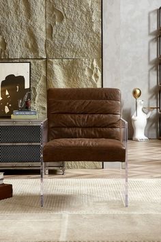 a living room with a brown chair and a white vase on the floor next to it