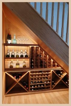 an under the stairs wine rack with bottles and glasses