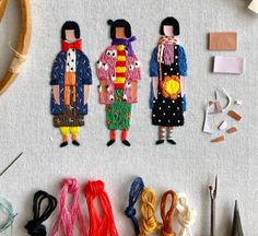 three people are standing next to each other with different types of thread and scissors in front of them