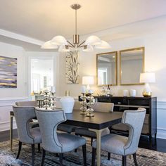 a dinning room table and chairs in front of a mirror with lights on it