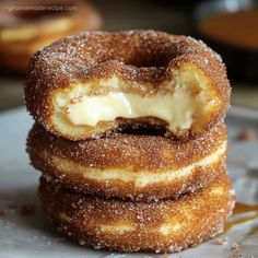 three donuts stacked on top of each other with icing and powdered sugar