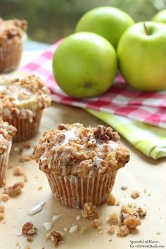 some muffins are sitting on a table next to green apples