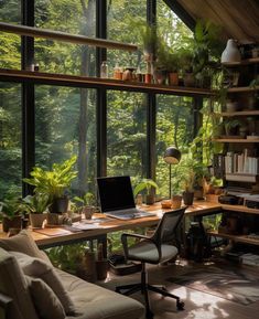 a laptop computer sitting on top of a wooden desk in front of a large window