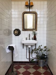 a bathroom with a sink, mirror and toilet paper dispenser in it