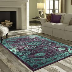 a living room filled with furniture and a rug on top of a hard wood floor