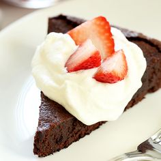 a piece of chocolate cake with whipped cream and strawberries on top