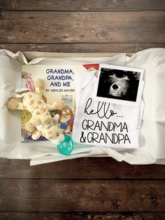 an open book and some stuffed animals on a wooden table next to a sign that reads grandma granda and me