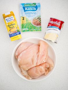 chicken, ranch seasoning and other ingredients on a white counter top with a bowl of chicken