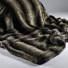 an animal fur blanket is laying on top of a tablecloth that has been folded over it