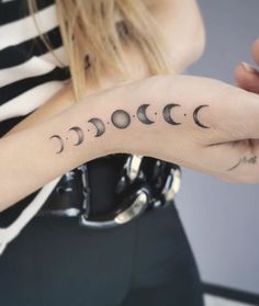 a woman's arm with phases tattooed on it